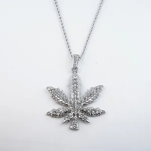 Close-up detail of a silver hip hop necklace featuring an iced-out leaf pendant