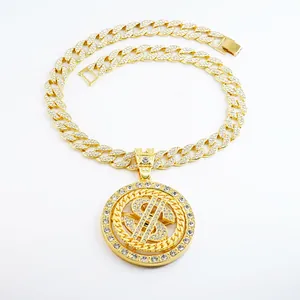 Détail du pendentif rotatif avec signe dollar serti de strass sur chaîne cubaine dorée