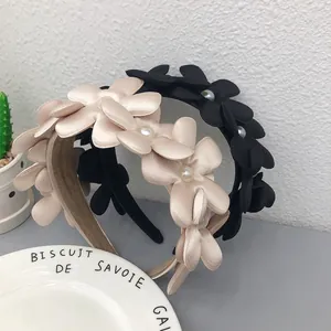 Dettaglio di cerchietti in tessuto con fiori e perle dallo stile francese chic