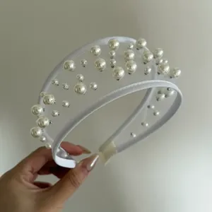 Vista dettagliata della fascia in tulle bianco decorata con perle eleganti e design