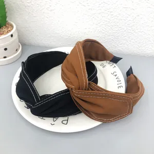 Primo piano di cerchietti a incrocio con eleganti cuciture bianche a contrasto.