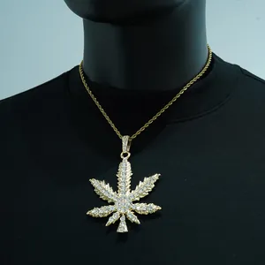 Close-up of iced out marijuana leaf pendant on a gold rope chain hip hop necklace