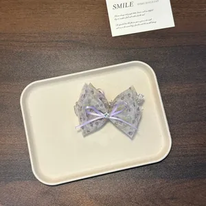 Detailansicht einer eleganten lila geblümten Organza-Haarklammer auf einem Tablett