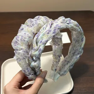 Detailed view of the purple floral pleated headband with rhinestone accents and bubble texture.