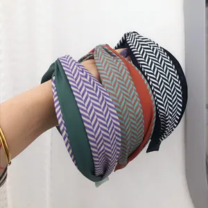 Dettaglio di cerchietti larghi con motivi a spina di pesce e colori a contrasto vivaci.