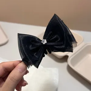 Elegant black mesh ribbon bow hair claw clip featuring a delicate crystal flower center