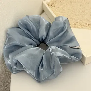 Vue détaillée d'un grand chouchou en organza bleu scintillant et irisé de haute qualité