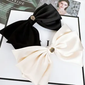Detail von eleganten großen Satin-Haarschleifen-Clips mit Vintage-Rosen-Metalldekor