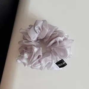 Détail d'un grand chouchou en organza lavande avec une texture de maille brillante
