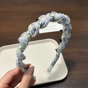 Detailed view of the purple floral pleated headband with rhinestone accents