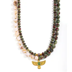 Detailed close-up of a vintage double-strand beaded necklace with a golden eagle pendant
