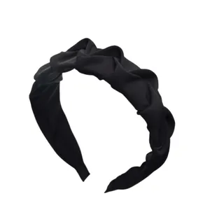 Nahaufnahme eines minimalistischen schwarzen gefalteten Haarreifs mit eleganter Stoffstruktur