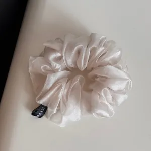 Vue détaillée d'un chouchou en organza blanc scintillant pour un style élégant
