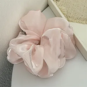 Détail d'un chouchou en organza rose nacré avec une texture brillante élégante