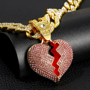 Dettagli degli strass rosa scintillanti su un ciondolo a cuore spezzato placcato oro