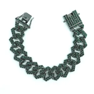 Gros plan sur un bracelet gourmette Cuban link en métal gris avec strass verts
