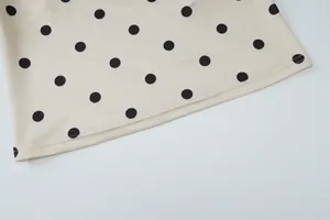 Macro-opname van de hoogwaardige zoom en stiksels van een beige mouwloze top met stippen