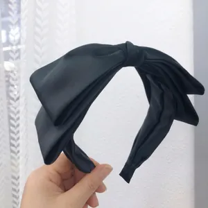 Elegant black satin bow headband for women featuring a stylish high top knot design