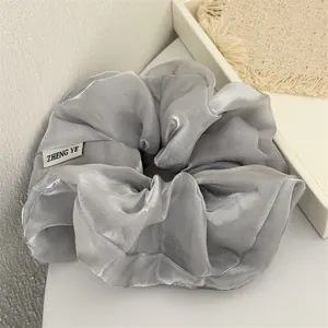 Gros plan d'un chouchou en organza gris perlé élégant avec une texture chatoyante