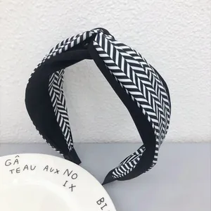 Primo piano di una fascia per capelli annodata in bianco e nero con motivo a spina di pesce