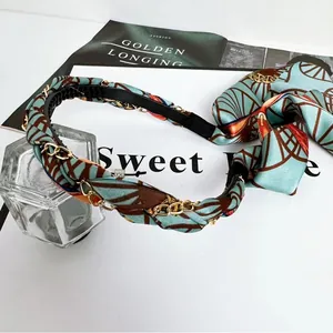 Dettaglio del cerchietto vintage in raso intrecciato con catena oro e sciarpa chic