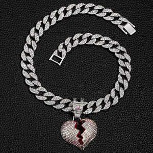 Primo piano di un ciondolo a cuore spezzato ghiacciato con catena cubana argento