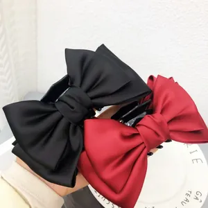 Gros plan détaillé de grandes pinces à cheveux avec nœud en satin noir et rouge élégantes