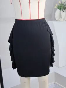 Detail showing chic ruffle trim on the sides of a black knitted pencil skirt.