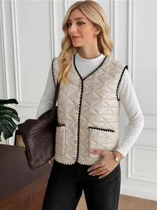 Detailed view of women's beige quilted vest featuring black serrated trim and woven bag