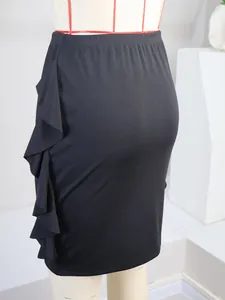 Detail of black knit bodycon skirt featuring elegant side ruffles and fitted silhouette