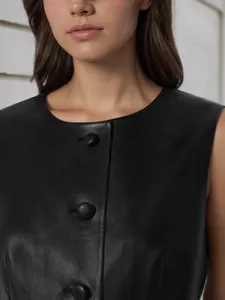 Close-up of a women's black sleeveless vest showing round neck and button detail
