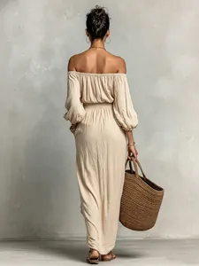 Elegante Rückansicht eines aprikosenfarbenen Maxikleides mit Puffärmeln und Strohtasche