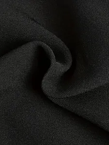 Detaillierte Makroansicht der glatten Textur und des Falls von schwarzem Stretch-Hosenstoff