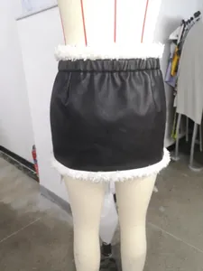 Dettaglio di una minigonna in pelle PU nera con bordo in peluche bianco su un manichino