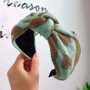 Detailed view of the mint green and brown knitted leopard print knotted headband.