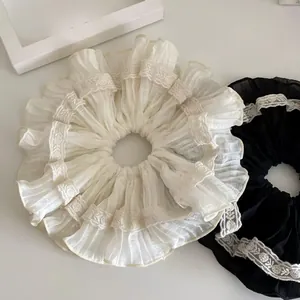 Dettaglio degli elastici per capelli in pizzo plissettato stile francese bianco e nero
