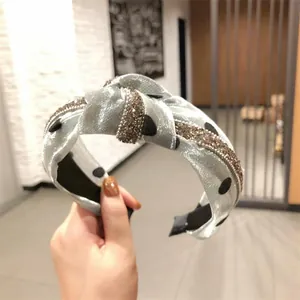 Dettaglio del cerchietto in organza a pois azzurro con bande di strass scintillanti.