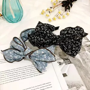 Close-up of vintage floral oversized bow headbands in elegant black and blue colors