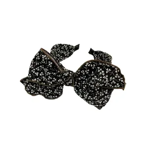 Vintage black headband with large bow and white floral pattern for women
