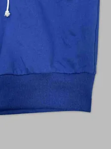 Close-up detail of the ribbed hem and soft fabric texture on a blue sports hoodie