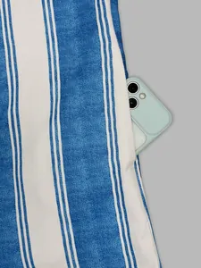 Detailed macro shot of a functional side pocket on a blue and white striped jumpsuit