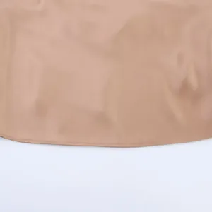 Makroaufnahme der glatten Satinstruktur und des sauberen Saums eines beige Oberteils