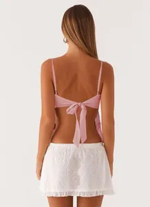 Back view of pink sequined camisole with tie-up bow and white lace skirt