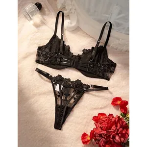 Detailed macro shot of sexy black sheer lace lingerie set with delicate rose embroidery.