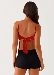 Back view of red sequin halter top with a stylish self-tie bow design on a female model.