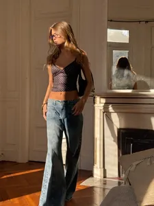 Trendy black camisole with white polka dots, styled with jeans for a slim summer look.