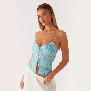 Close-up of a blue sequined V-neck camisole with tie-front and slim fit details.