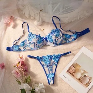 Detailed view of blue floral embroidered sheer lingerie set with romantic lifestyle props