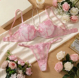 Detail shot showing the elegant pink rose floral embroidery on sheer lace lingerie.