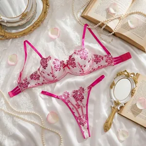 Elegant fuchsia rose embroidery lingerie set on silk background with lace details.